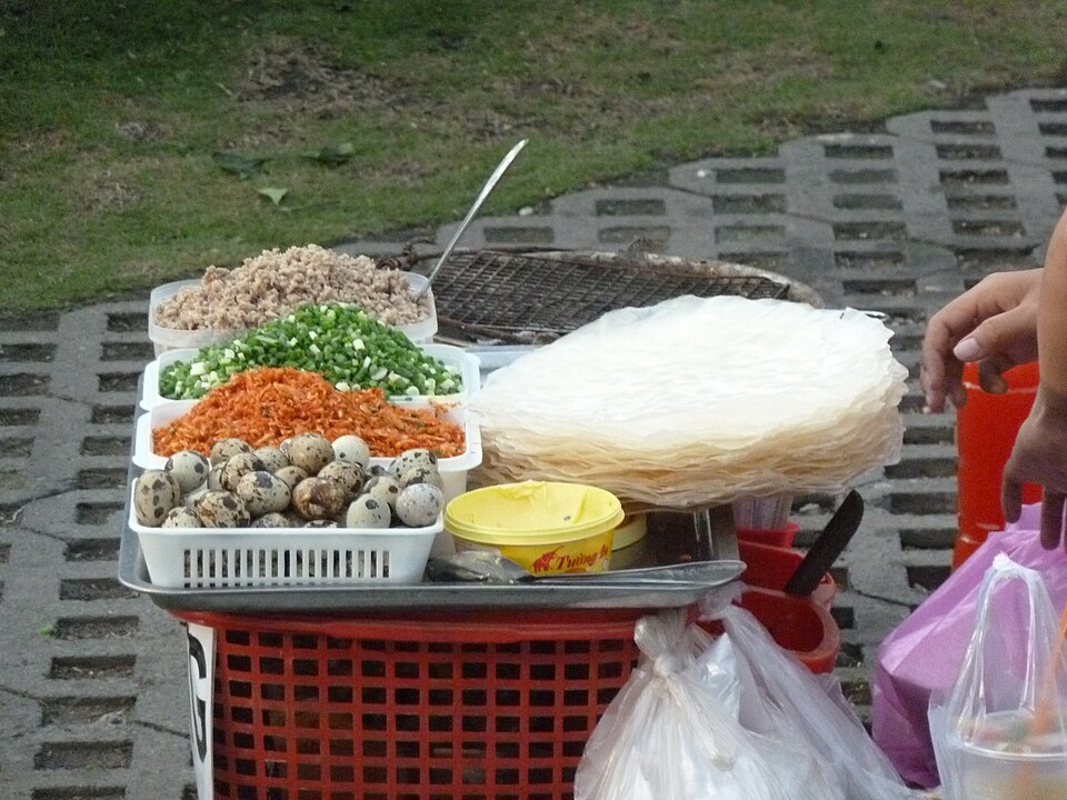 Rice paper, quail eggs and fresh toppings at a bánh tráng nướng stall in Saigon